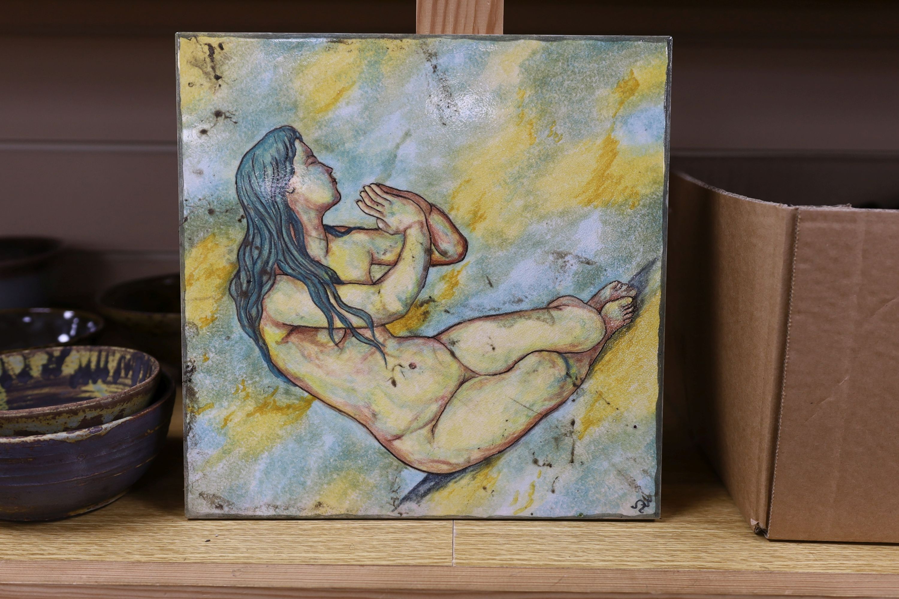 A large pottery figural tile together with a collection of studio pottery bowls